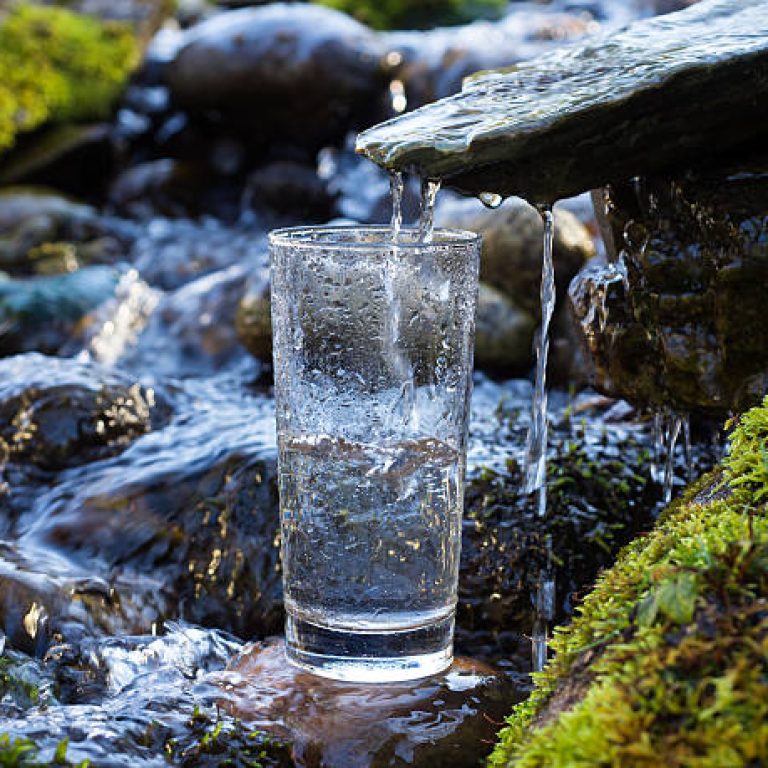 Natural drinking water is being poured into glass